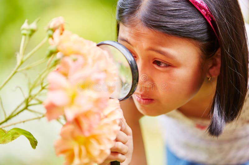 Girl with magnifying glass explores nature as reseracher. Girl with magnifying glass explores nature as reseracher