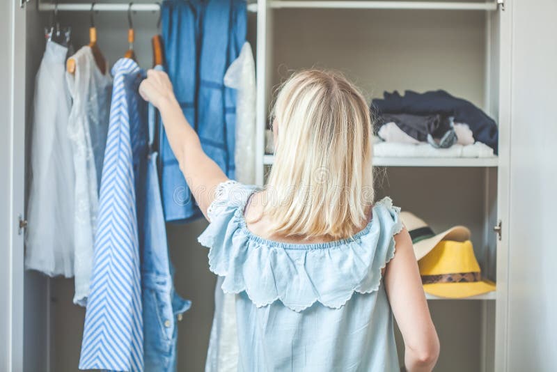 Mädchen nahe einer Garderobe mit Kleidung kann was nicht wählen zu tragen Schweres auserlesenes Konzept hat nichts zu tragen stockbild Mädchen nahe einer Garderobe mit Kleidung kann was nicht wählen zu tragen Schweres auserlesenes Konzept hat nichts zu tragen stockbild
