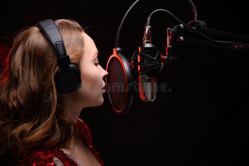 Mädchen singt im Studio, ein spektakuläres Foto eines stimmungsvollen Musikers im Studio mit rotem Rauch Unterschiedliche Musikst lizenzfreie stockbilder Mädchen singt im Studio, ein spektakuläres Foto eines stimmungsvollen Musikers im Studio mit rotem Rauch Unterschiedliche Musikst lizenzfreie stockbilder