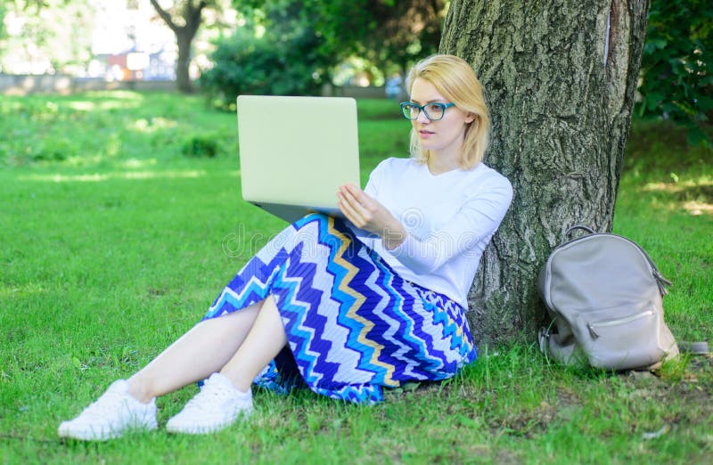 Girl sit grass lean tree trunk with notebook. Lady freelancer working in park. Wi fi network connection free access. Woman with laptop works outdoor, park background. Taking advantages of free wi fi. Girl sit grass lean tree trunk with notebook. Lady freelancer working in park. Wi fi network connection free access. Woman with laptop works outdoor, park background. Taking advantages of free wi fi.