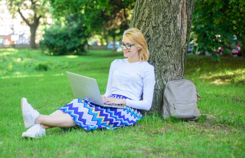 Girl sit grass lean tree trunk with notebook. Wi fi network connection free access. Lady freelancer working in park. Woman with laptop works outdoor, park background. Taking advantages of freelance. Girl sit grass lean tree trunk with notebook. Wi fi network connection free access. Lady freelancer working in park. Woman with laptop works outdoor, park background. Taking advantages of freelance.