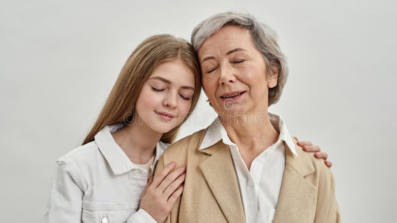 Mädchen umarmt ihre Senior Großmutter im Studio stockfotos