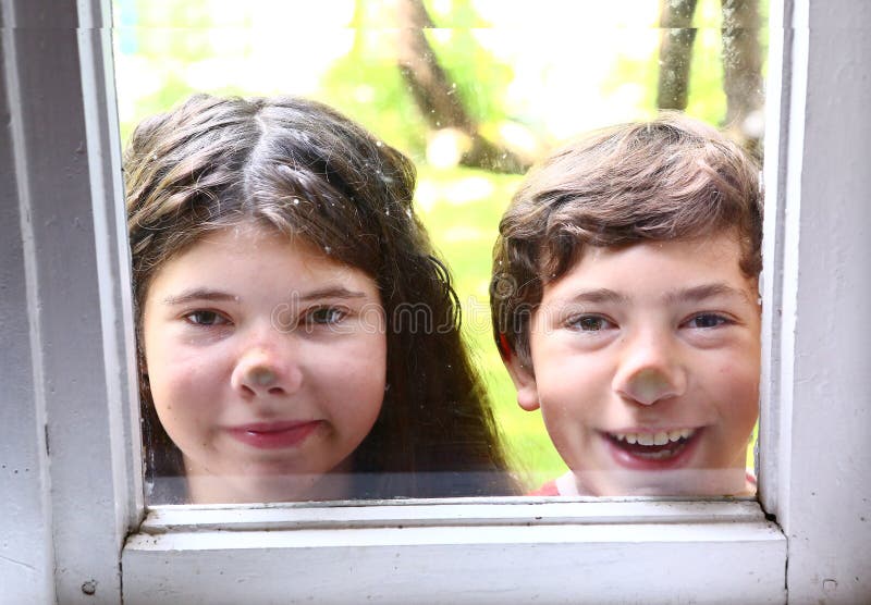 Mädchen und Junge mit Nase bedrängten gegen Fenster lizenzfreie stockfotos Mädchen und Junge mit Nase bedrängten gegen Fenster lizenzfreie stockfotos