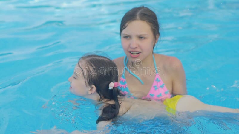 Mädchen unterrichtet ihre jüngere Schwester zu schwimmen