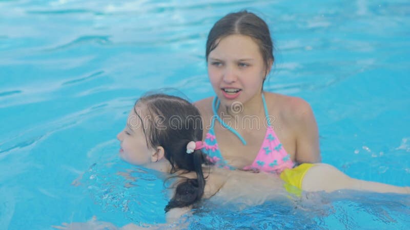 Mädchen Unterrichtet Ihre Jüngere Schwester Zu Schwimmen Stock Video - Video von draussen, trainer: 107392677