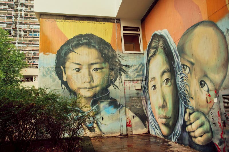 Mädchen von einer Flüchtlingsfamilie auf der Wand mit Straßenkunst lizenzfreie stockfotografie Mädchen von einer Flüchtlingsfamilie auf der Wand mit Straßenkunst lizenzfreie stockfotografie