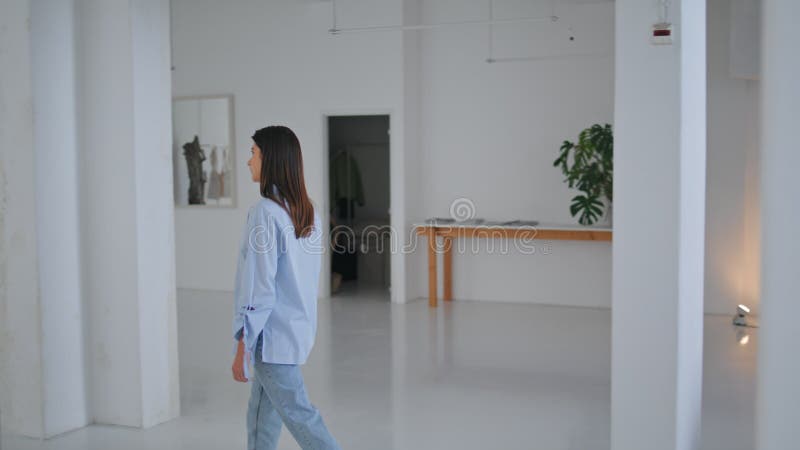 Mädchen überquert moderne Galerie am Wochenende. aufmerksamer Besucher, der Grünpflanzen sieht