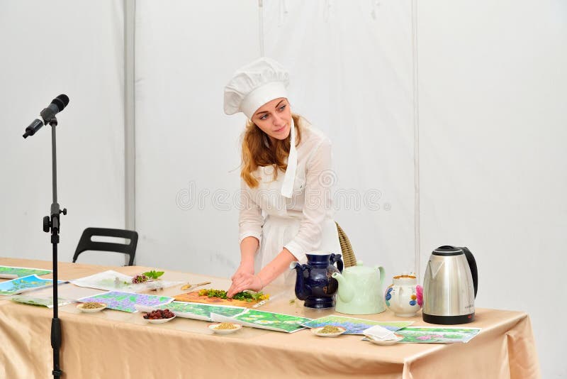Mädchenchef, der Kräutertee an der Darstellung am festiv zubereitet stockfotos Mädchenchef, der Kräutertee an der Darstellung am festiv zubereitet stockfotos