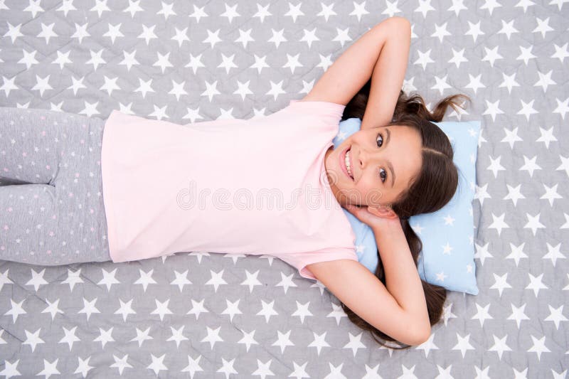 Girl child long hair lay awake top view. Quality of sleep depends on many factors. Girl lay on little pillow full of energy in morning bedclothes background. Choose proper pillow to sleep well. Girl child long hair lay awake top view. Quality of sleep depends on many factors. Girl lay on little pillow full of energy in morning bedclothes background. Choose proper pillow to sleep well.