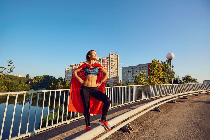 Mädchenläufer in einem Superheldkostüm auf der Straße in der Stadt stockbild Mädchenläufer in einem Superheldkostüm auf der Straße in der Stadt stockbild