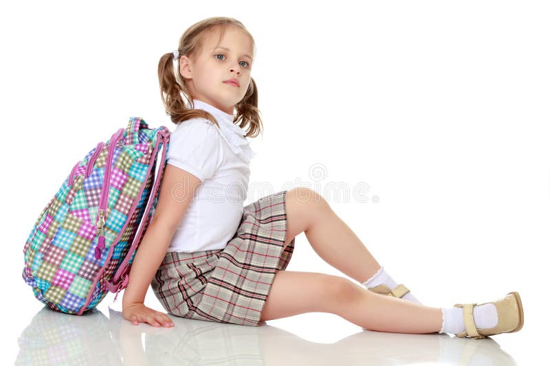 Mädchenschulmädchen, das auf dem Boden sitzt lizenzfreies stockbild