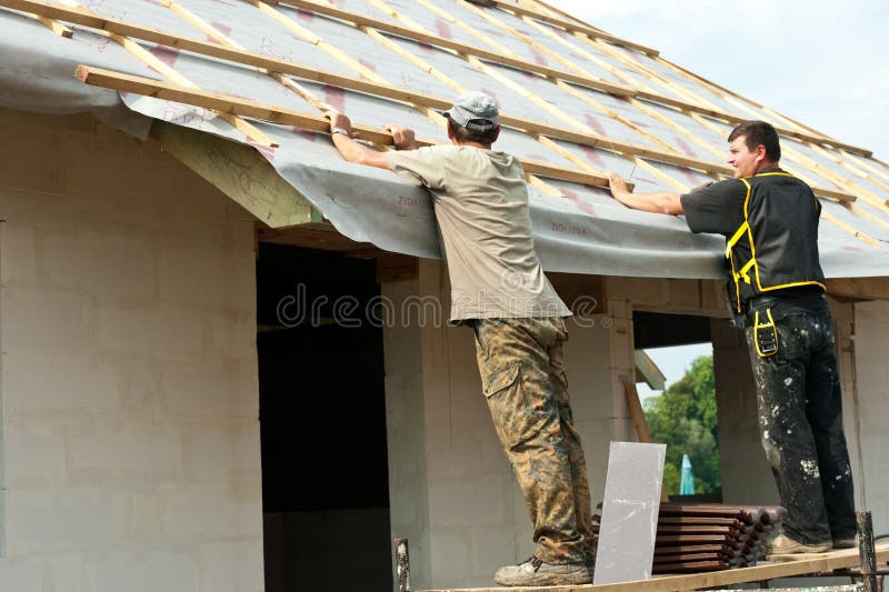 Männer, die Dach auf ein Haus setzen
