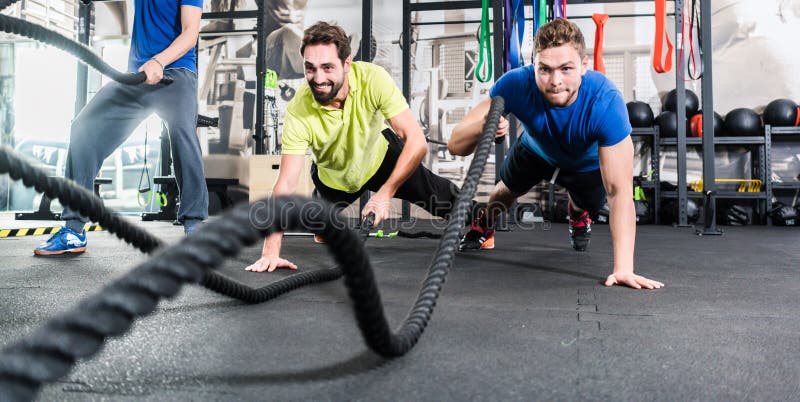 Men with battle rope in functional training fitness in gym. Men with battle rope in functional training fitness in gym