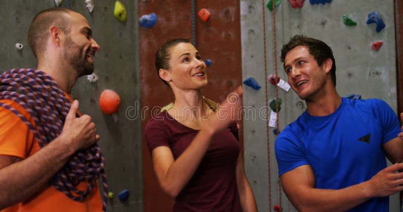 Männer und Frau, die an der bouldering Turnhalle 4k aufeinander einwirken