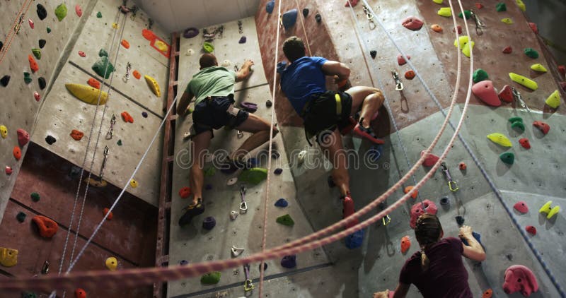 Männer und Frau, die eine künstliche Wand an bouldering Turnhalle 4k klettern