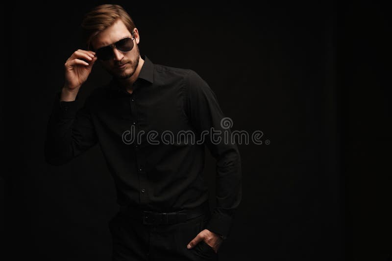 Männer in vollem Anzug. selbstbewusster junger Geschäftsmann in Sonnenbrille auf schwarz stehend. stockbilder