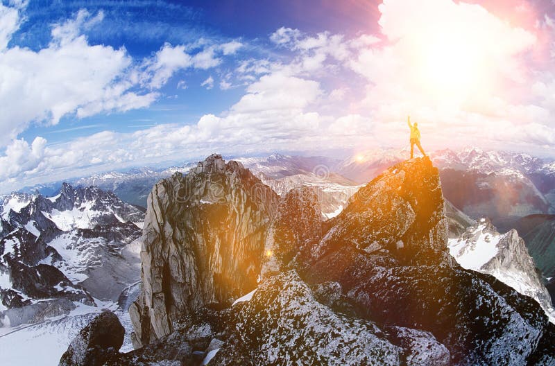 Male hiker celebrating at the top of the mountain against strong lens flare. Male hiker celebrating at the top of the mountain against strong lens flare