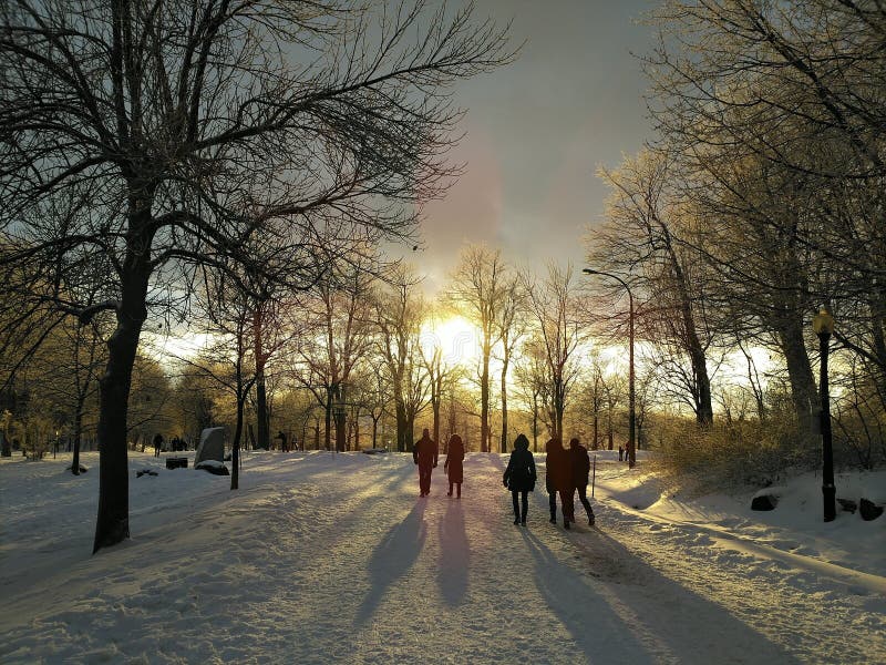 Människor som går på snöstigen vid solnedgången arkivbilder