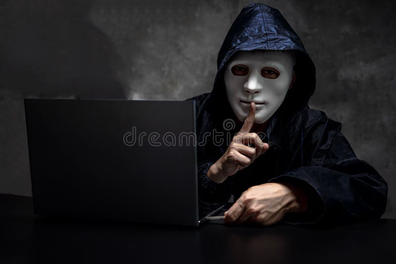 Männliche Hacker versteckt Gesicht mit der Maske und Kapuze. verdunkeltes dunkles Gesicht machen Stille Geste versuchen zu hacken stockfoto