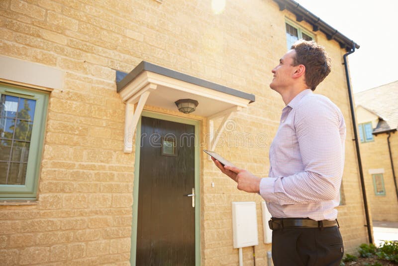 Male real estate agent looking up at a house exterior. Male real estate agent looking up at a house exterior