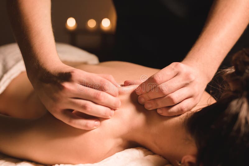 Männlicher Arbeiter, der Badekurortmassage von Schultern und von Hals junges Mädchen in der Dunkelkammer antut stockfotos Männlicher Arbeiter, der Badekurortmassage von Schultern und von Hals junges Mädchen in der Dunkelkammer antut stockfotos