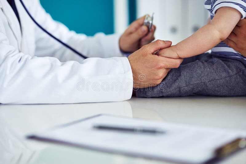 Männlicher Doktor überprüft ein Kind in einer Klinik lizenzfreies stockbild Männlicher Doktor überprüft ein Kind in einer Klinik lizenzfreies stockbild