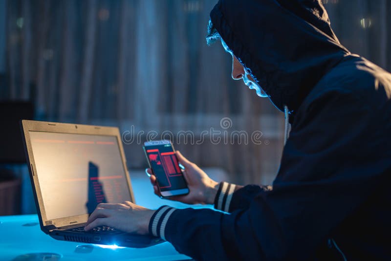 M? nnlicher Hacker in der Haube, die das Telefon in seinen H? nden versuchen, Zugangsdatenbanken mit Passw? rtern zu stehlen h? lt Cy stockfoto