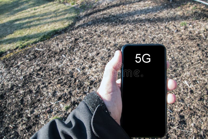 Männlicher Handholding Smartphone in seiner linken Hand Der Schirm sagt 5G Ein schwarzer Jackenärmel ist sichtbar Es gibt ein G stockfotos Männlicher Handholding Smartphone in seiner linken Hand Der Schirm sagt 5G Ein schwarzer Jackenärmel ist sichtbar Es gibt ein G stockfotos
