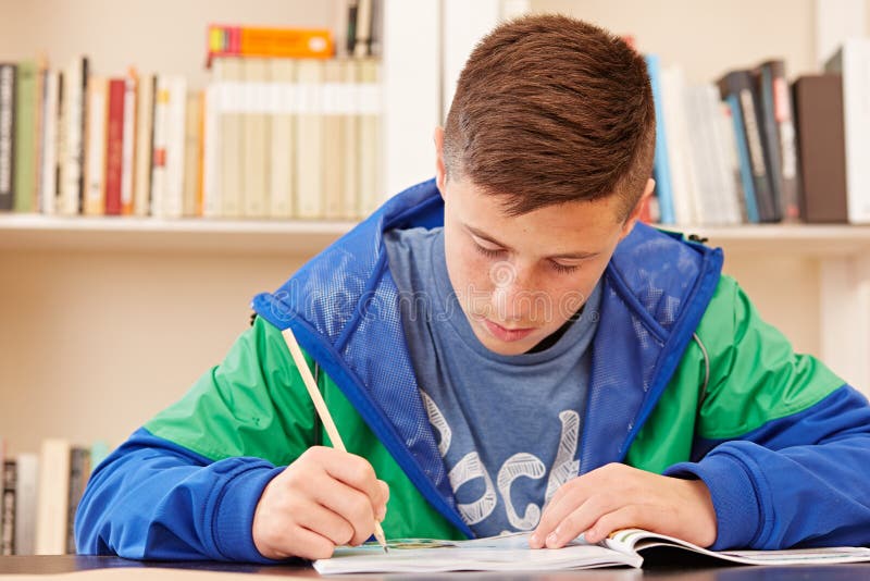 Männlicher Jugendlicher konzentriert, Hausarbeit tuend stockbild Männlicher Jugendlicher konzentriert, Hausarbeit tuend stockbild