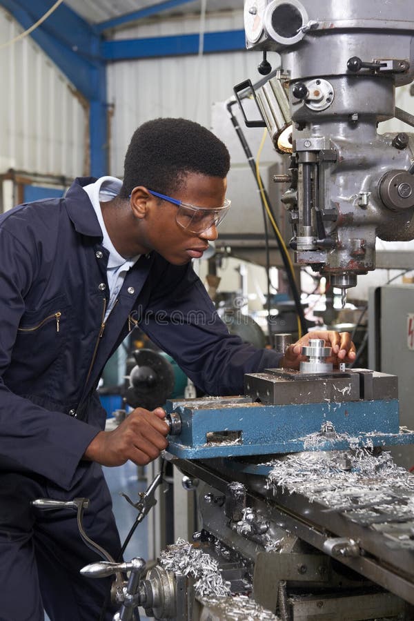 Männlicher Lehrlings-Ingenieur Working On Drill in der Fabrik stockbild Männlicher Lehrlings-Ingenieur Working On Drill in der Fabrik stockbild