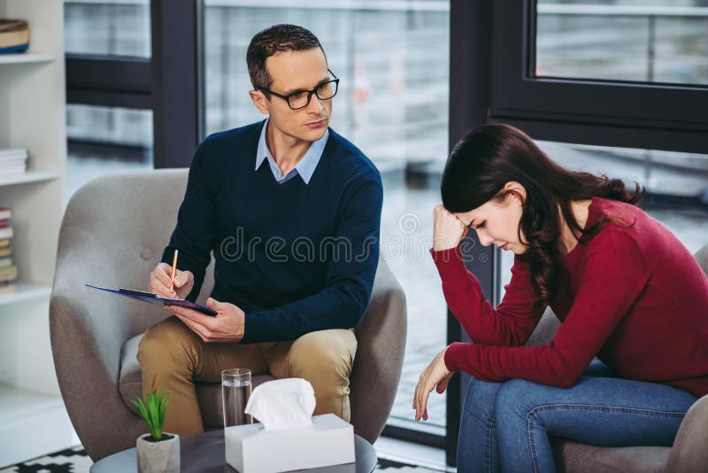 Männlicher Psychologe, der auf Patienten hört stockbild Männlicher Psychologe, der auf Patienten hört stockbild