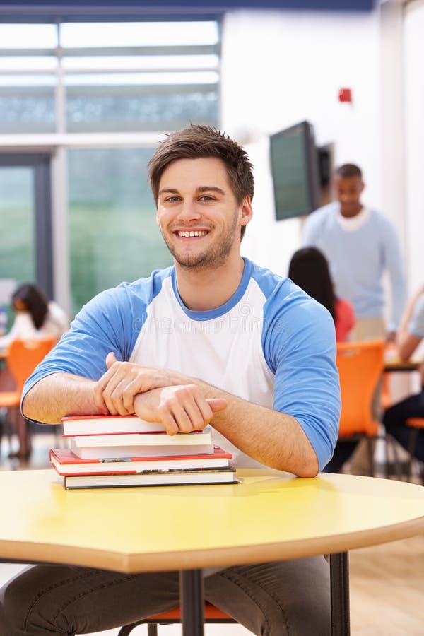 Männlicher Student Studying In Classroom mit Büchern stockbild Männlicher Student Studying In Classroom mit Büchern stockbild
