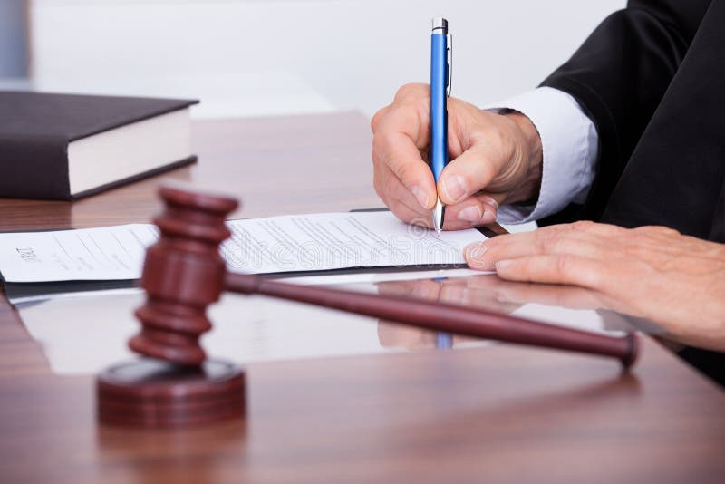 Male Judge Writing On Paper In Courtroom. Male Judge Writing On Paper In Courtroom