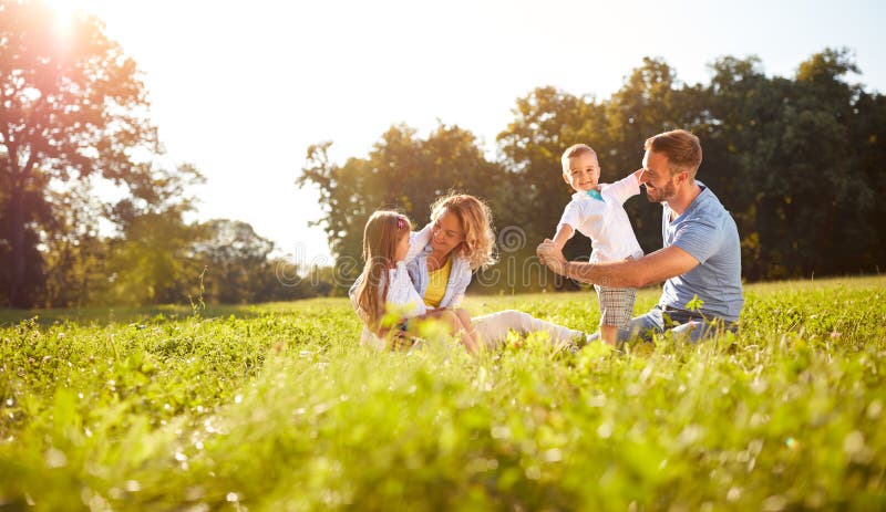 Männliches und weibliches Spielen mit Kindern draußen lizenzfreies stockbild
