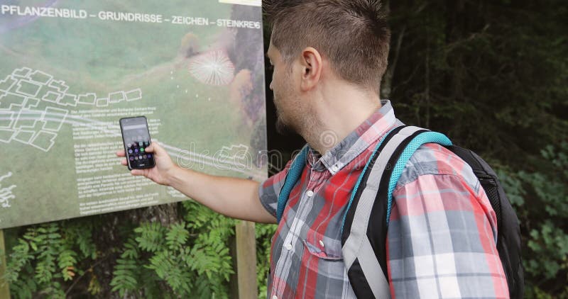 Mężczyzna bierze fotografii na telefonie komórkowym mapę park w górach