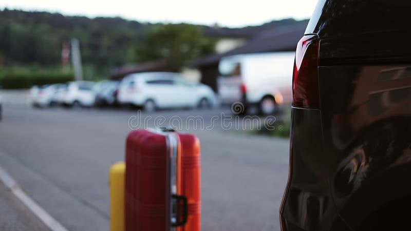 Mężczyzna stawia jaskrawe walizki w samochodzie turyści