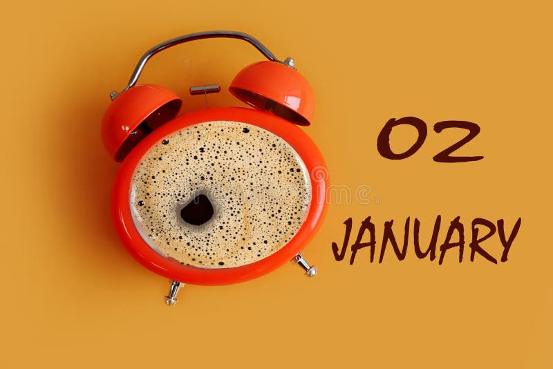 January 2 calendar: orange clock shaped coffee mug, name of the month january, numbers 02, yellow background, top view. January 2 calendar: orange clock shaped coffee mug, name of the month january, numbers 02, yellow background, top view.