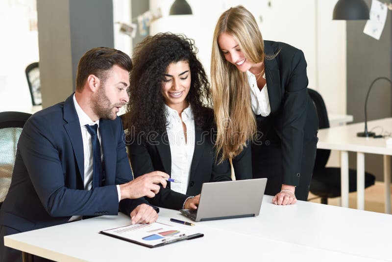 Mång--person som tillhör en etnisk minoritet grupp av tre businesspeople som möter i en modern nolla royaltyfria foton Mång--person som tillhör en etnisk minoritet grupp av tre businesspeople som möter i en modern nolla royaltyfria foton