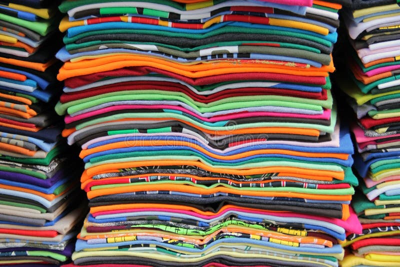 Många färgglada staplade T-shirts royaltyfri bild