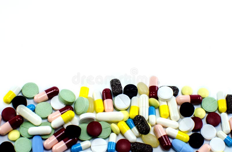 Många preventivpillerar av olika färger på en vit bakgrund royaltyfria bilder Många preventivpillerar av olika färger på en vit bakgrund royaltyfria bilder