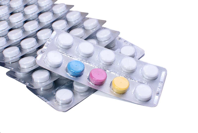 Många vit och några kulöra preventivpillerar i blåsapackar arkivbild Många vit och några kulöra preventivpillerar i blåsapackar arkivbild