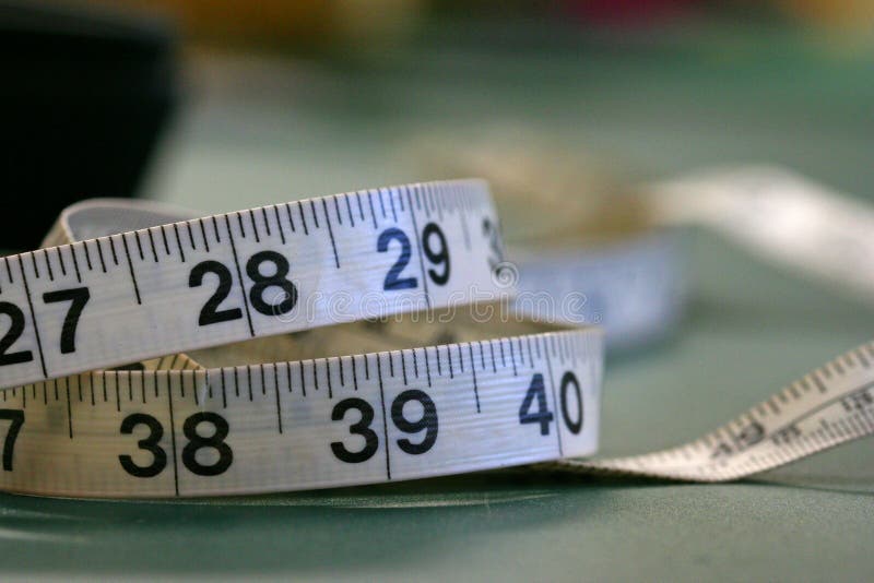 A tape measure laying on a table. A tape measure laying on a table.