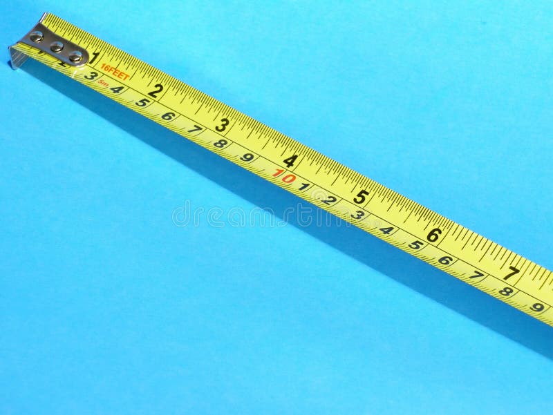 Tape measure on isolated blue background. Yellow against blue. Blue background is not constant but shades from bottom left to upper right corner. Tape measure on isolated blue background. Yellow against blue. Blue background is not constant but shades from bottom left to upper right corner.