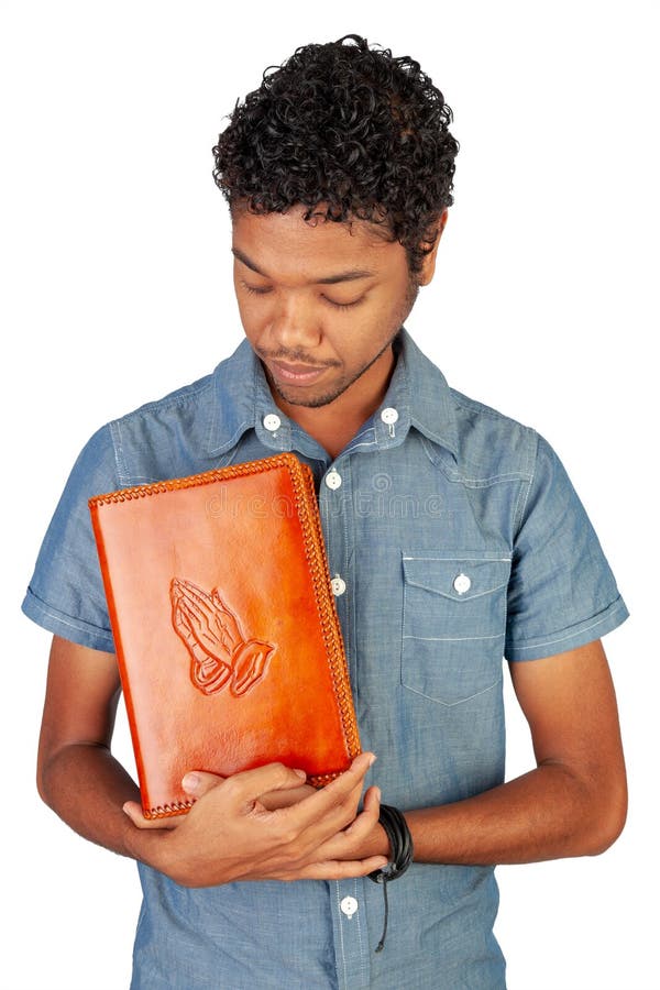 Young Indo-Mauritian or Creole Pastor in training holding a bible lovingly. Portrait format isolated on white background. Inspiration for poster with copy space for devotion, prayer circle or faith. Young Indo-Mauritian or Creole Pastor in training holding a bible lovingly. Portrait format isolated on white background. Inspiration for poster with copy space for devotion, prayer circle or faith