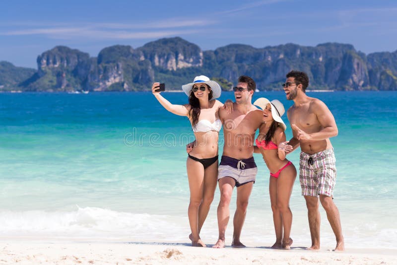 Young People Group On Beach Summer Vacation, Two Couple Happy Smiling Friends Taking Selfie Photo Sea Ocean Holiday Travel. Young People Group On Beach Summer Vacation, Two Couple Happy Smiling Friends Taking Selfie Photo Sea Ocean Holiday Travel