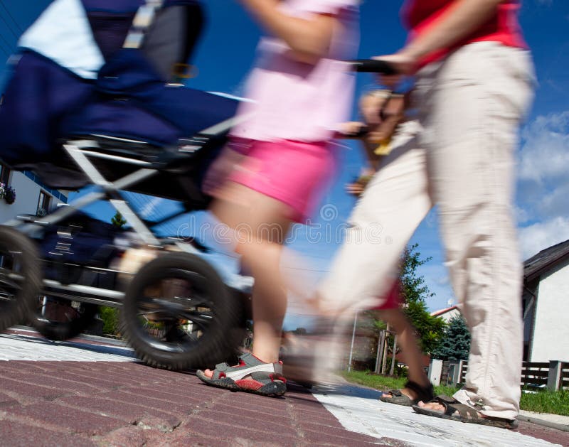 Mère avec de petits enfants et un landau traversant une rue photographie stock libre de droits Mère avec de petits enfants et un landau traversant une rue photographie stock libre de droits