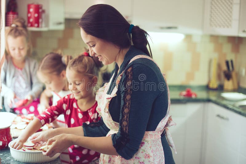 Mère avec des enfants à la cuisine photos libres de droits Mère avec des enfants à la cuisine photos libres de droits