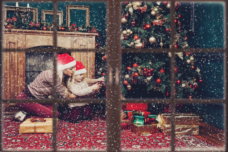 Mère avec l'arbre de Noël de port d'enfant avant nouvelle année photos libres de droits Mère avec l'arbre de Noël de port d'enfant avant nouvelle année photos libres de droits