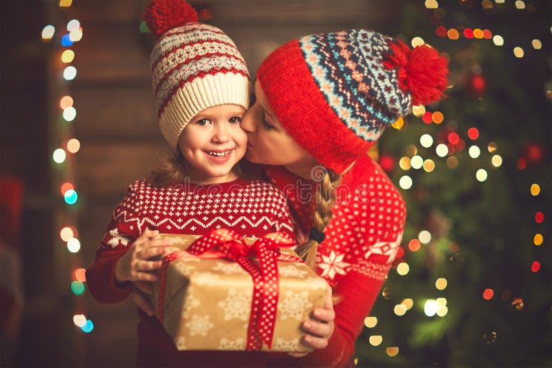 Mère de famille et fille heureuses d'enfant avec le cadeau de Noël image stock Mère de famille et fille heureuses d'enfant avec le cadeau de Noël image stock