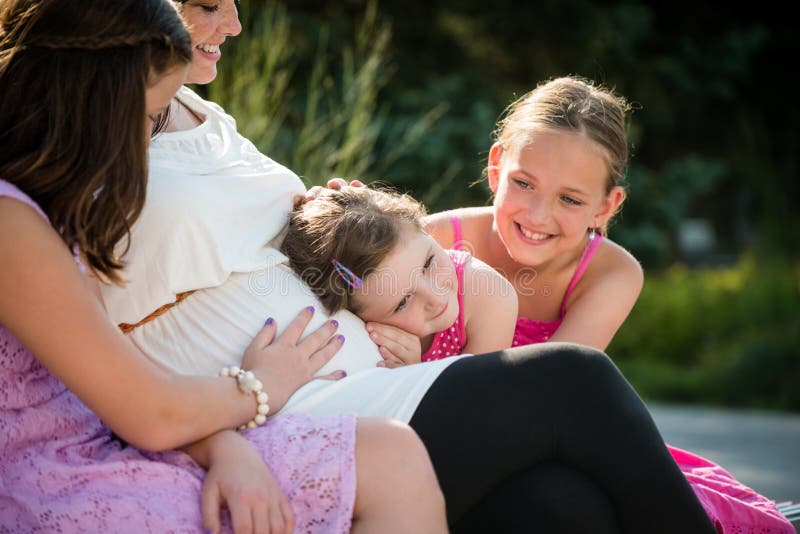 Mère enceinte heureuse avec des enfants extérieurs en nature d'été image libre de droits Mère enceinte heureuse avec des enfants extérieurs en nature d'été image libre de droits